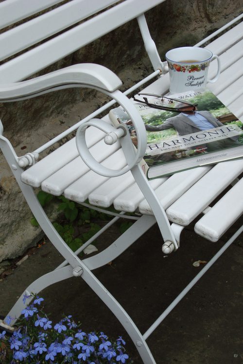 Gemütliche Leseecke im Garten mit Tee und Buch